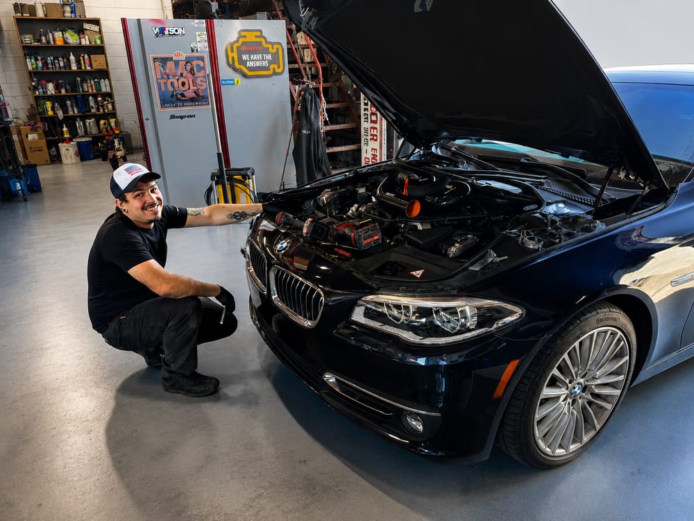 River City Autohaus technician servicing a BMW 5-Series in the shop
