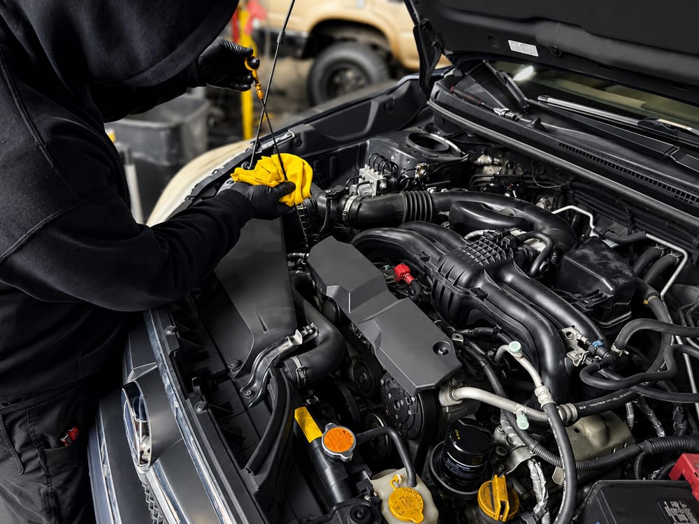 River City Autohaus technician checking the engine oil level on the dipstick during a full-service oil change