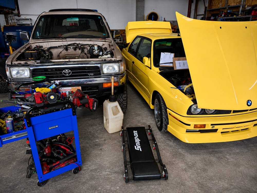 A yellow BMW E30 M3 and a Toyota 4Runner in for service at River City Autohaus in St. Helens, Oregon, with all makes and models welcome